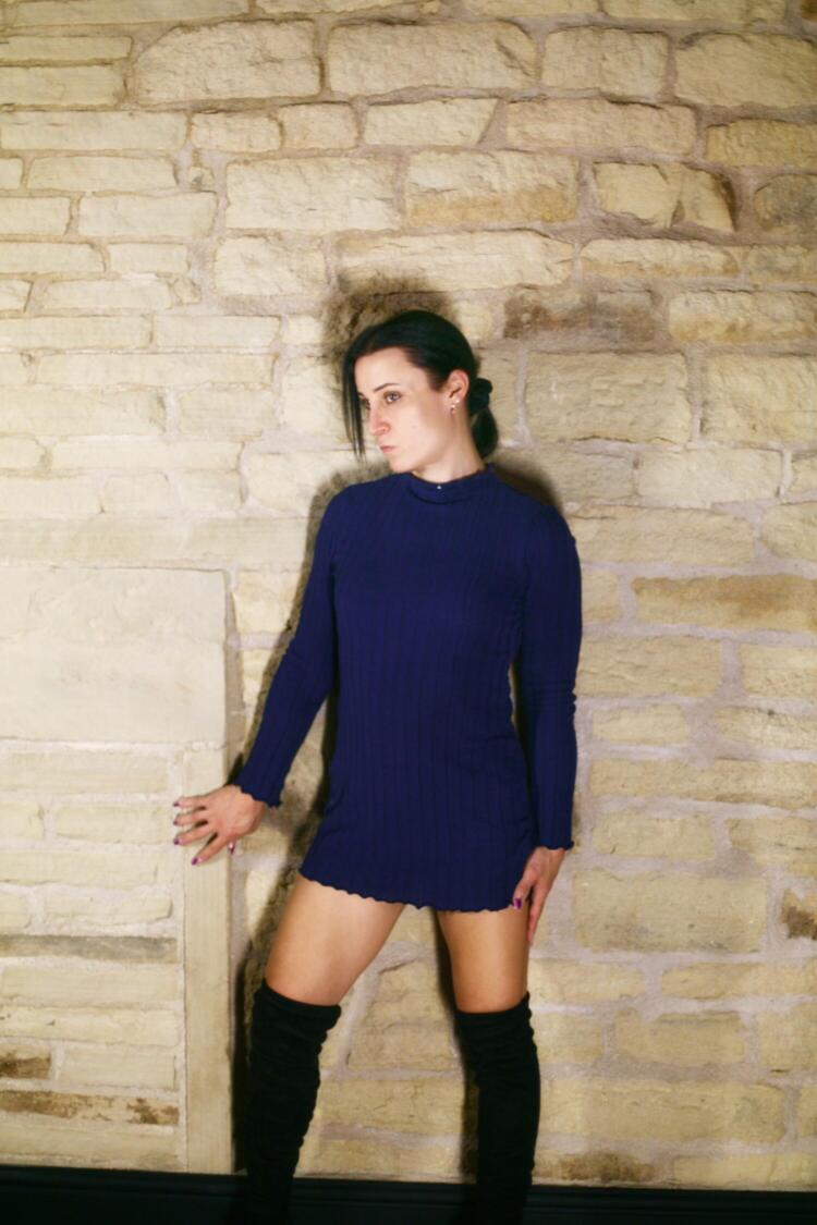 Trans escort Raye Wilde posing in dress in Wakefield apartment